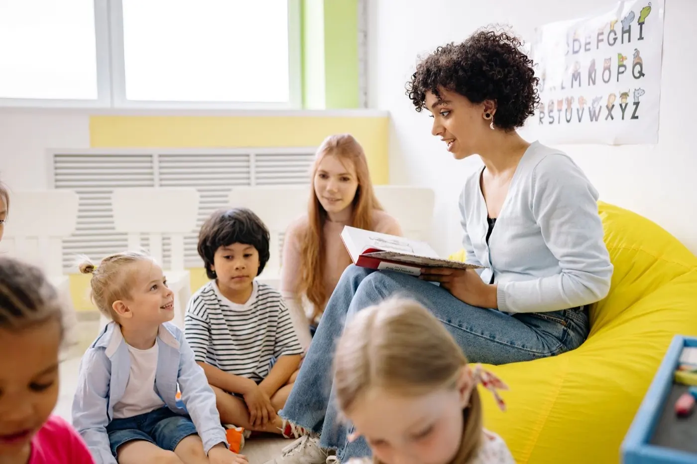 Teacher reading with young children in a classroom