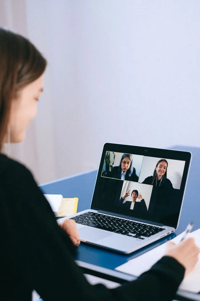 Parent on a video call taking notes during a remote meeting