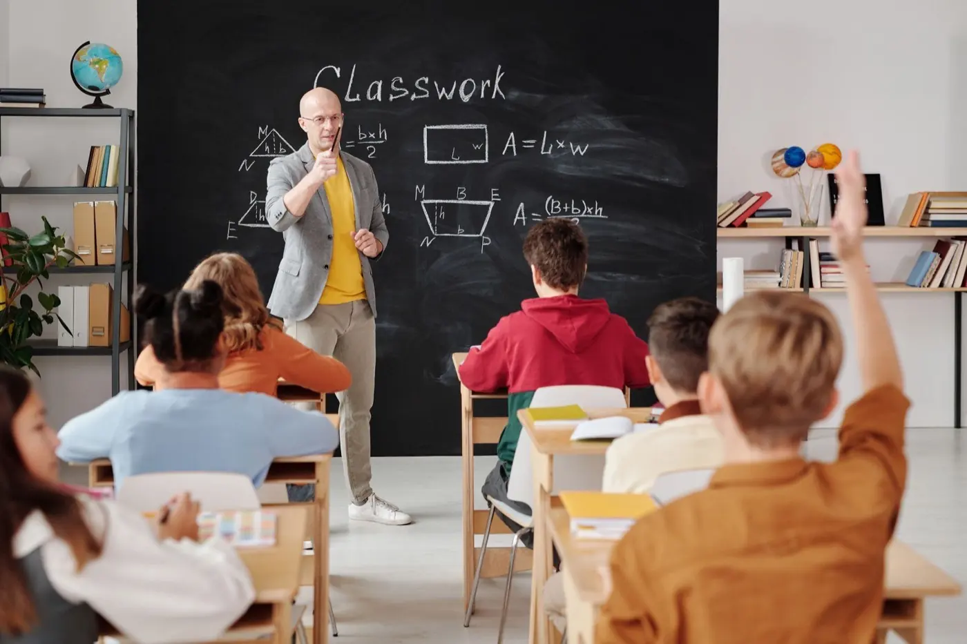 Teacher explaining a lesson at the front of a classroom